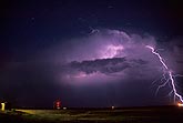Brilliant lightning strikes out from the top of a storm cloud