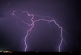 Two finely etched lightning bolts intersecting in mid-air