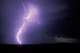 A brilliant electrifying cloud-to-ground lightning bolt misted by rain