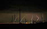 Distant lightning bolts wander through a power corridor