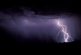 Two bright lightning bolts entwine each other as their paths cross