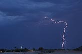 A single lightning bolt strikes in the twilight desert
