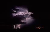 Three lightning forms light up a ghostly storm cloud