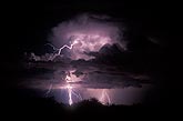 A lightning bolt shoots out from high in a storm cloud