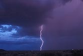 A lone positive lightning strike in a blue and purple twilight