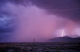 Subtle lightning with a heavy rain curtain with a soft pink sunset 