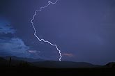 A single, bright, positive lightning bolt discharges