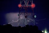 Lightning streamers behind a satellite communications tower