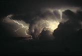 Cloud-to-cloud lightning and intracloud flashes with silhouetted clouds