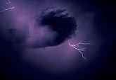 Dramatic cloud-to-air lightning fork in an inky stormy sky