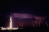 Cloud-to-ground lightning behind an oil drilling rig