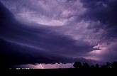 Intracloud lightning illuminates a shelf cloud at night