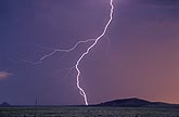Cloud-to-ground lightning bolt at sunset