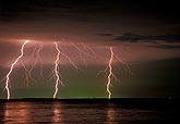 Lightning bolts in eerie green and pink sky