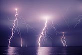 Close and distant lightning bolts over water