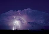 A Cumulonimbus storm cloud illuminated by a lightning strike