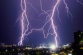 A discharge of lightning hits and explodes a transformer in a city