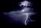 A powerful cloud-to-ground lightning bolt with in-cloud flashes above