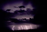 Distant bolts of lightning with cloud flashes above