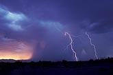 Lightning strikes at dusk with an amorphous wall of heavy rain