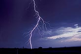 A single lightning bolt darts from the side of a thundershower