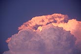 Sunset casts a surreal glow on a knuckled Cumulonimbus dome