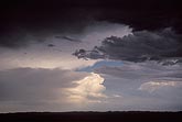 A glistening white storm viewed from under a dark cloud