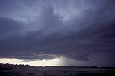 A threatening dark cloud lowers in a stormy sky
