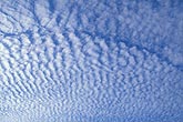 Abstract of a ripple pattern with a thin clear blue slice of sky