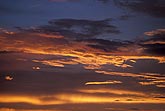 A sunset sky with clouds lined with luxurious gold and red color