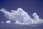 Towering Cumulus clouds boil and freeze over mountains