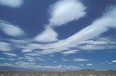 Smooth streaks and patches of middle cloud soar across the desert