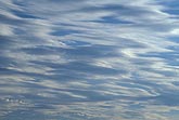 Sinuous clouds suggest speed and change as they zoom across the sky