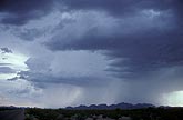A small thunderstorm cloud with a heavy rainshower over mountains