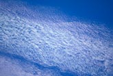 Pale irisation in a finely textured diaphanous cloud abstract