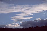 Ascending streaks of stippled cloud in a brooding twilight sky