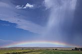A low rainbow and rain unite to offer hope
