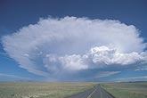 An isolated Cumulonimbus cloud down a lonely road