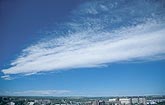 A streak of woolly cloud soars in a deep blue sky