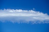 A strip of feathered Altocumulus cloud floats in a pure blue sky