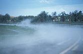 Steam fog lifts from the surface of a road after a hailstorm