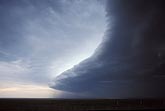 Contrasting storm clouds advance: bright anvil and dark shelf cloud