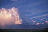 A twilight storm cloud looks evanescent with its soft, dreamy anvil