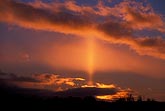 Golden sun pillar in a deep red sunrise sky