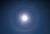 A halo rings the sun in a veil of thin Cirrostratus