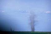 A large dust devil and another, smaller one over a dry field
