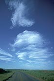 Whirling poofs of wispy clouds dance in a deep blue sky