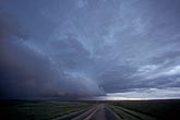 The foreboding leading edge of a storm over a lonely road