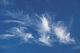 Joyous dancing cloud tufts in a deep blue sky