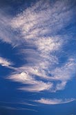 Carefree arcs of cloud grace a deep blue sky